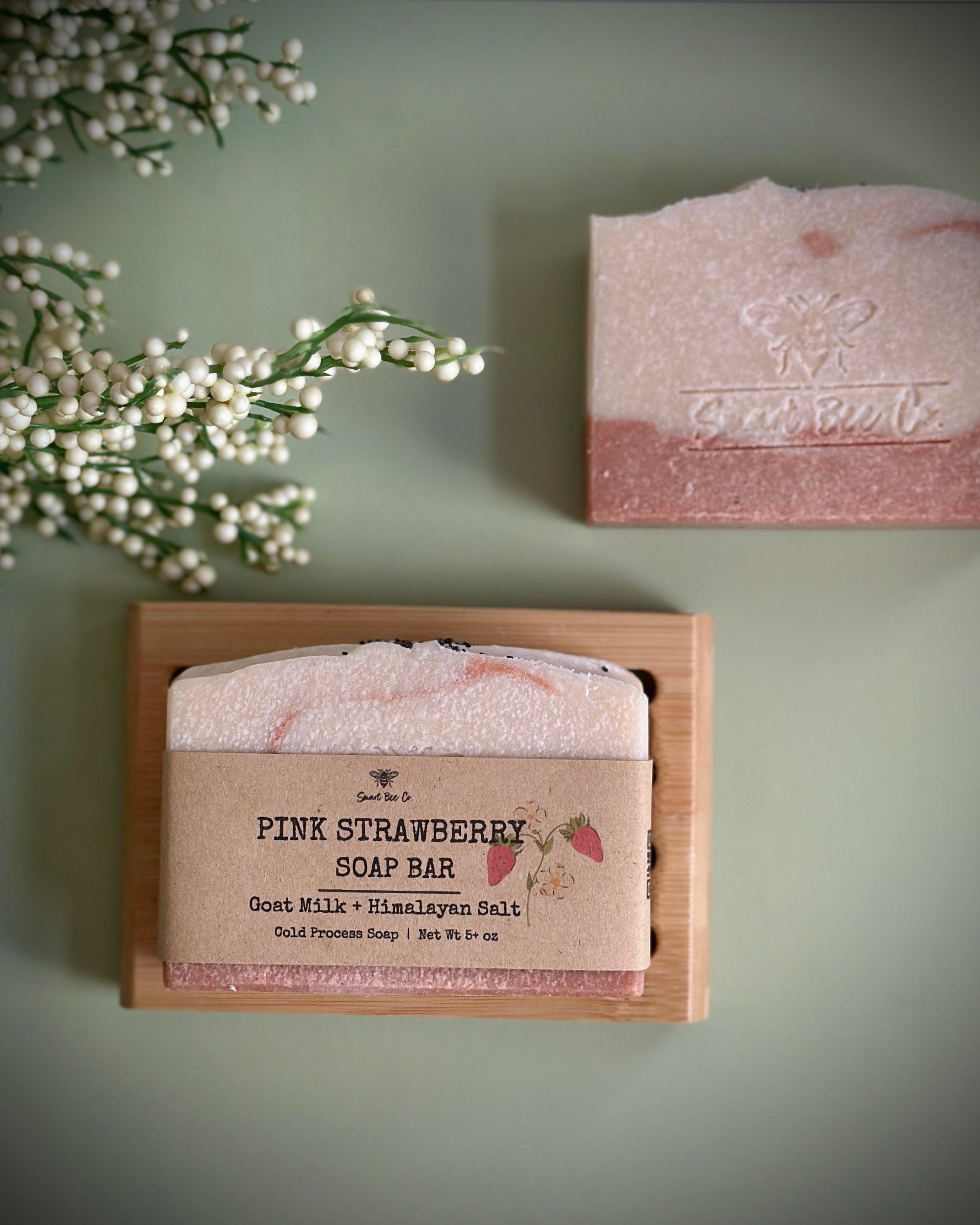 Pink strawberry soap bar in a wooden box with a green background