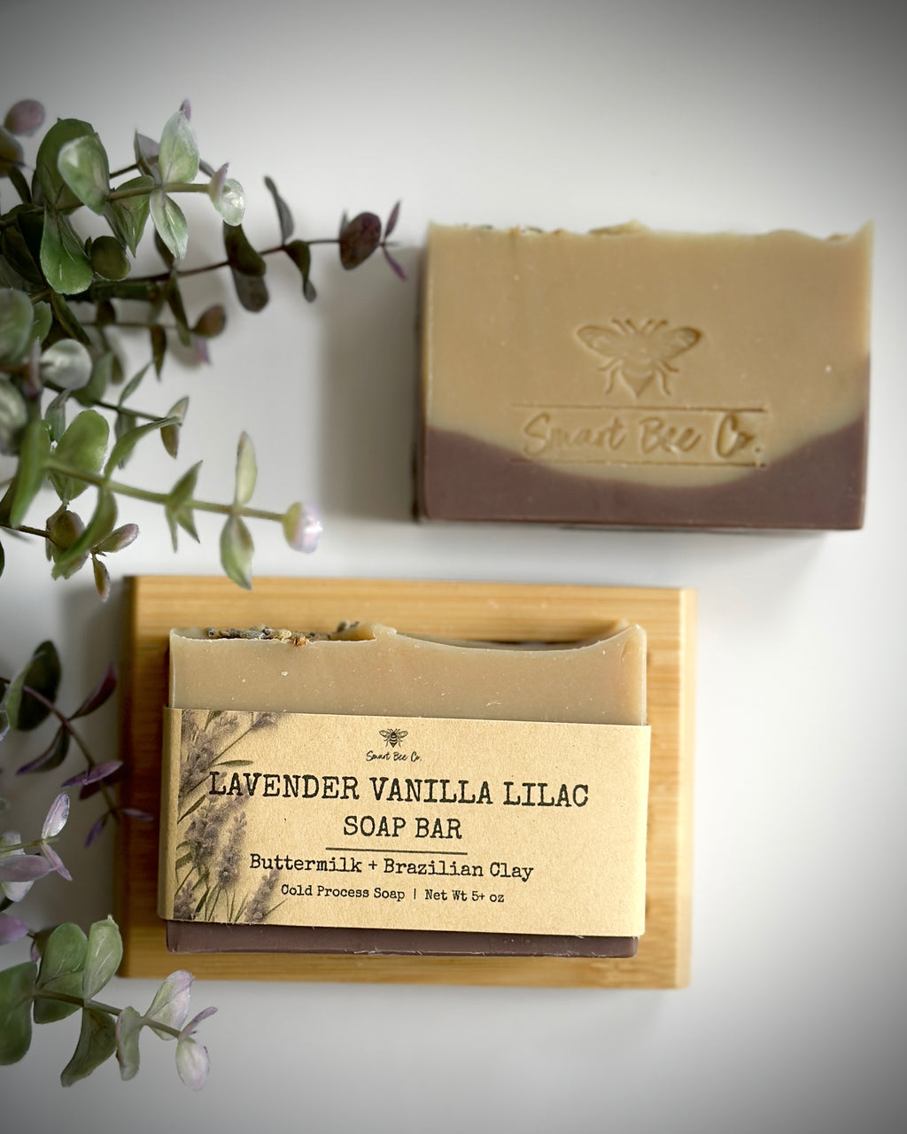 Soap bar with a wooden soap dish and 'Sweet Bee Co.' branding on a light background.