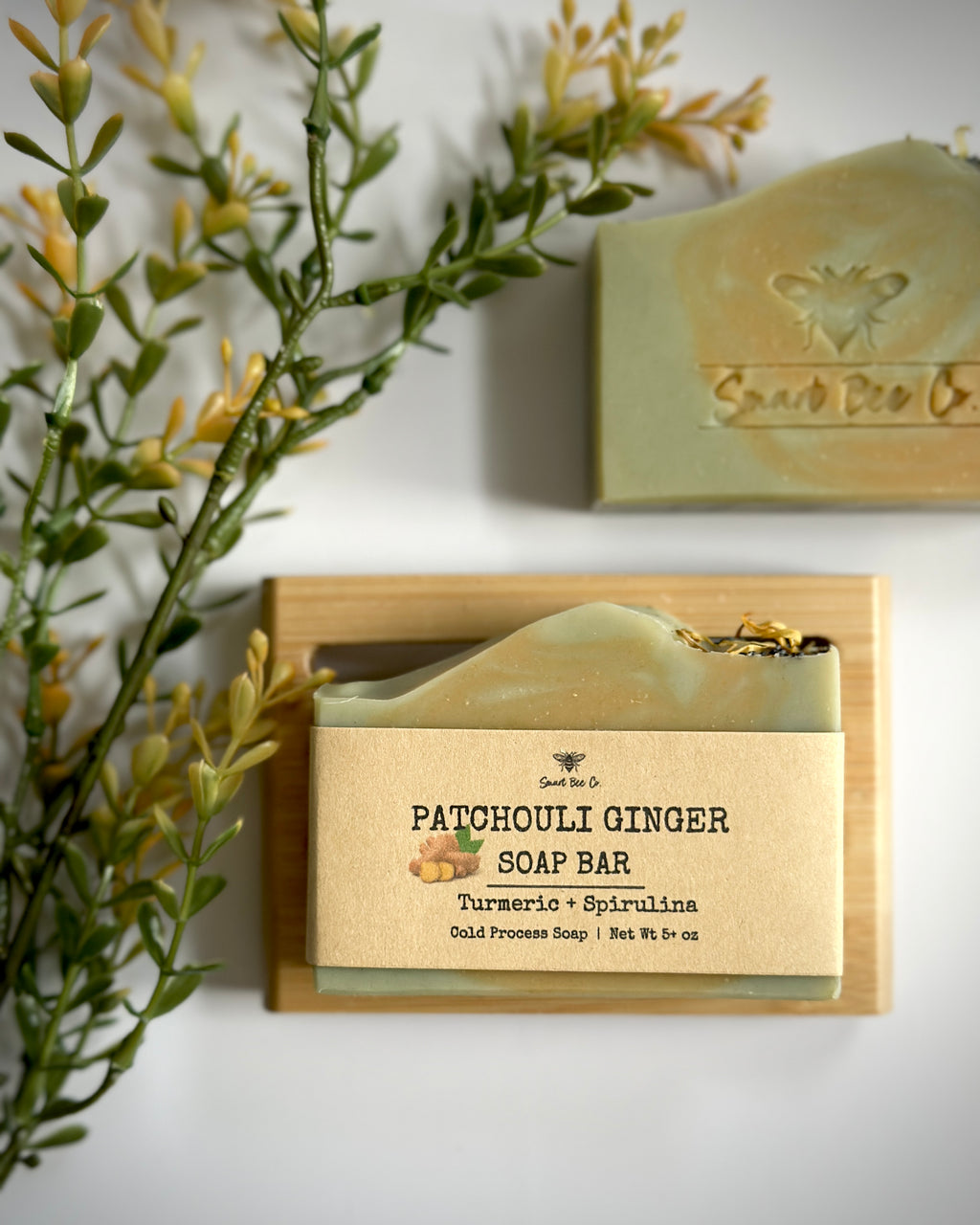 Patchouli Ginger soap bar with a wooden holder on a white background