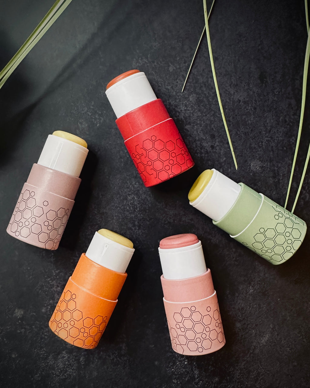 Set of six cylindrical containers with honeycomb patterns on a dark surface